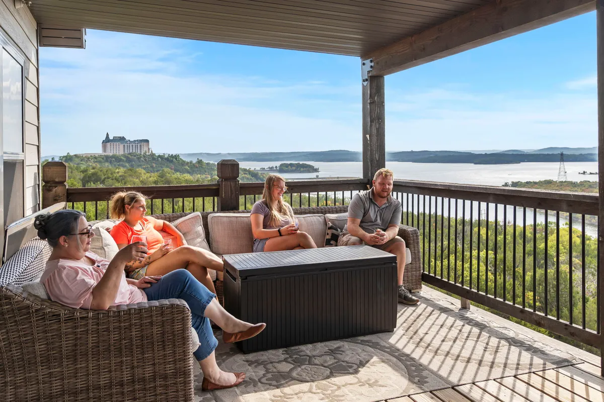 A welcoming outdoor seating area where a group of people is gathered, set against a backdrop of scenic views. Comfortable furniture and relaxed body language suggest a space designed for socializing, conversation, and celebrating special moments together.